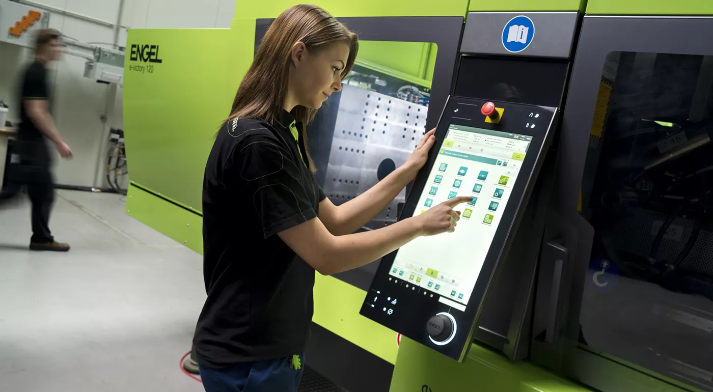 Woman operating ENGEL CC300 via touch screen machine control