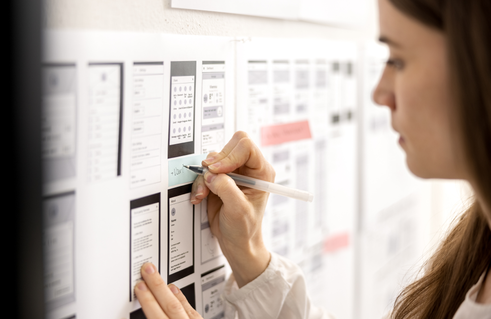 UX/UI Designerin macht Notizen zu Wireframes